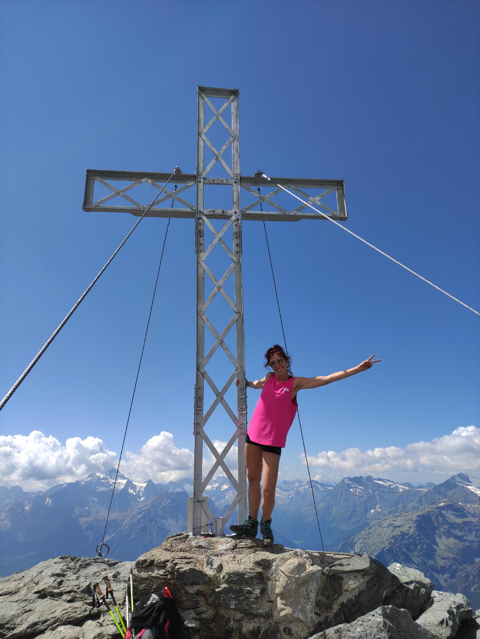 La croce di vetta del Pizzo Scalino, sullo sfondo il Monte Disgrazia e le montagne della Valmalenco